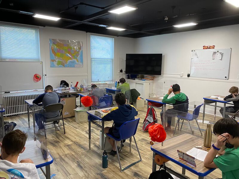 Group of students sitting at desks in classroom setting.