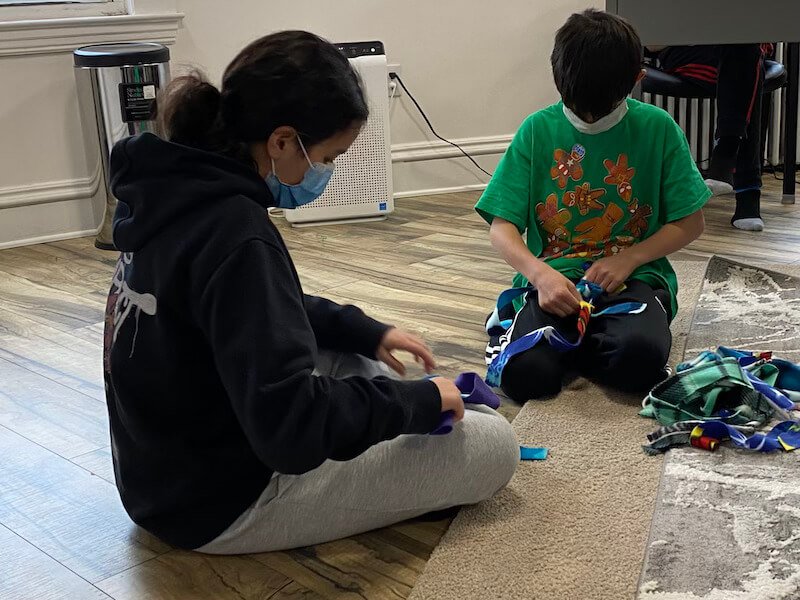 Two students engaged in blanket making activity.